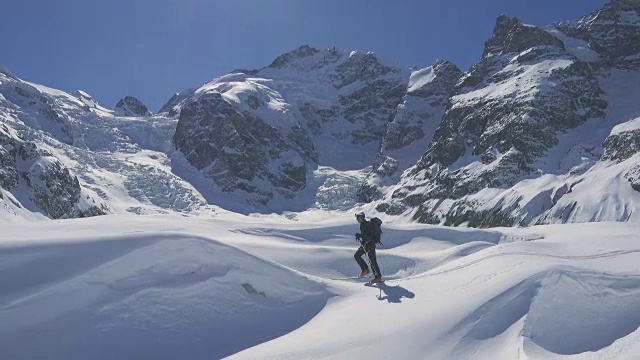 在冰川或群山环绕的新雪上滑雪视频素材