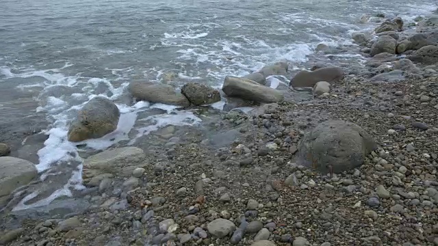 海浪翻滚到多塞特海岸的卵石滩上。视频素材