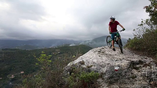 山地车下降岩石崖壁以上的道路和山谷视频素材