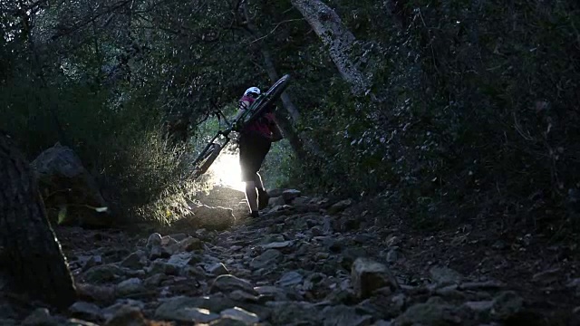 山地自行车通过森林隧道上升，在小路上视频素材