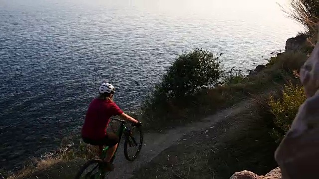 山地摩托车手沿着海岸线行驶，眺望大海视频素材