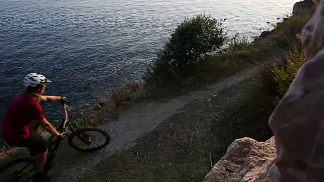 山地摩托车手沿着海岸线行驶，眺望大海视频素材