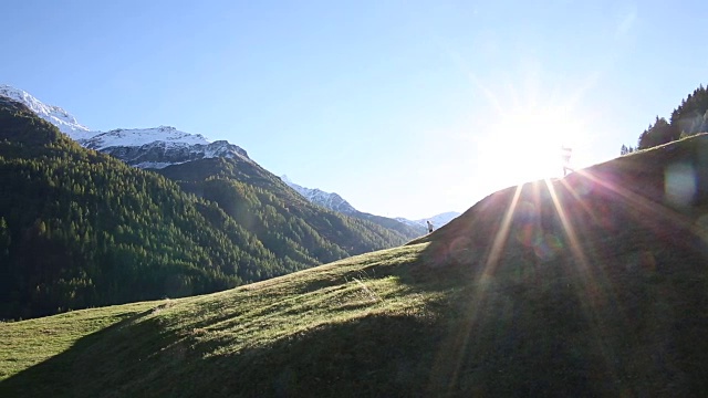 徒步旅行的情侣们沿着山脊上的草甸走着视频素材