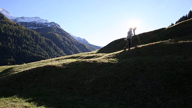 徒步旅行的情侣们沿着山脊上的草甸走着视频素材