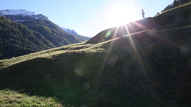 徒步旅行的情侣们沿着山脊上的草甸走着视频素材