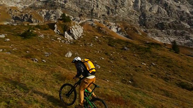 一名中年男子骑自行车穿过山区草地视频素材