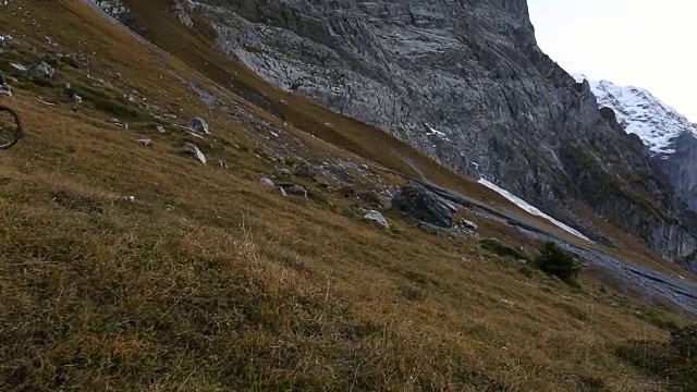 一名中年男子骑自行车穿过山区草地视频素材