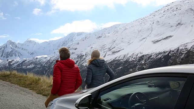 夫妇下车，仰望山路到雪峰视频素材