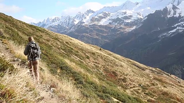 男性徒步者沿着小路穿过山坡，雪山视频素材