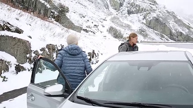 男女下车，在暴风雪中仰望山腰视频素材