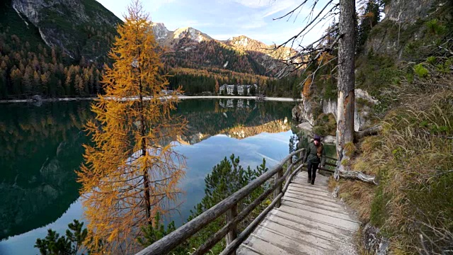 女人走在山间高山湖旁边的小路上视频素材