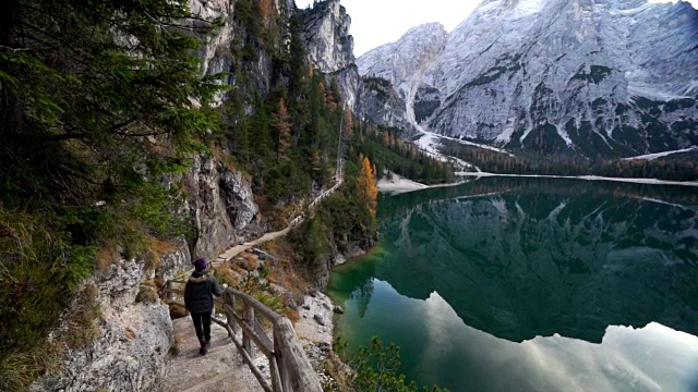 女人走在山间高山湖旁边的小路上视频素材