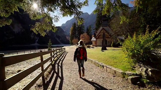 女人走在山间高山湖旁边的小路上视频素材