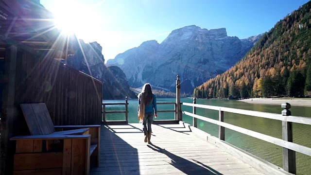 一个女人走在码头上眺望高山湖泊视频素材