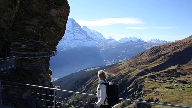 女性徒步旅行者沿着山坡上有守卫的小路行走视频素材