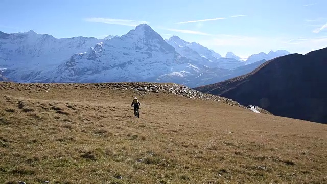 骑山地车的人穿过山上的草地视频素材