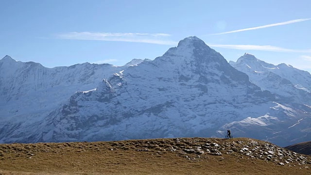 骑山地车的人穿过山上的草地视频素材