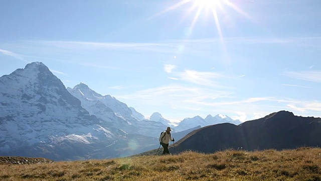 女性徒步旅行者攀登草地，雪山盖顶视频素材