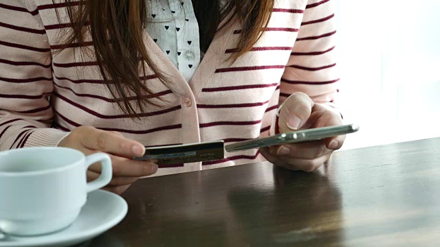 一个女人在电话里输入信用卡信息视频素材