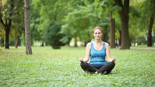 一个女孩在公园里做瑜伽视频素材