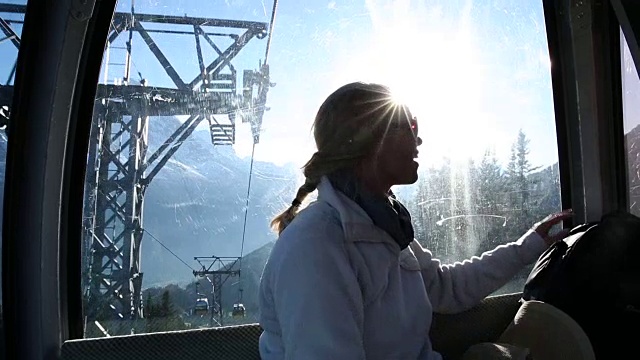 女子乘坐缆车向雪山走去视频素材