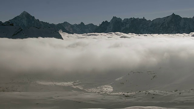 在法国阿尔卑斯山脉的Haute Savoie地区的Tête à的山顶上，一个云的倒转坐落在积雪覆盖的山谷上视频素材