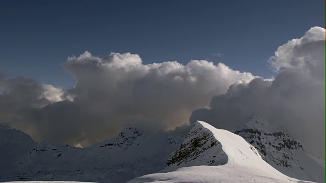 在法国阿尔卑斯山脉的豪特萨伏伊地区，巨大的积云堆积在雪山的山顶上视频素材