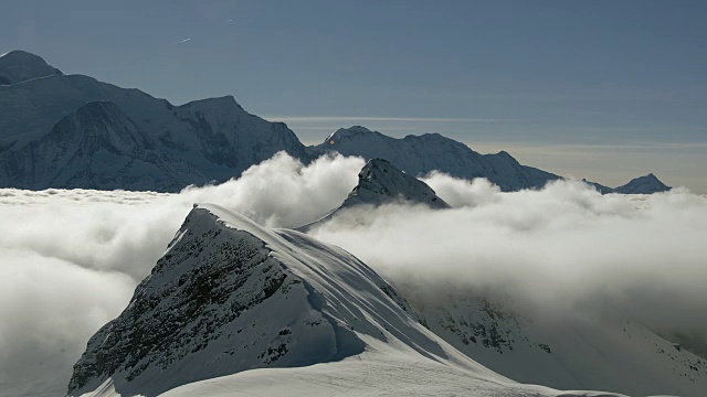 在法国阿尔卑斯山脉的豪特萨伏伊地区，一团逆温云在积雪覆盖的山脊上形成并经过视频素材