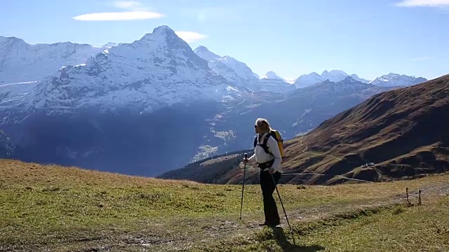 女性徒步旅行者沿着小路穿过山地草地视频素材