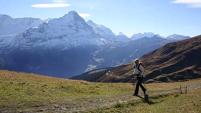 女性徒步旅行者沿着小路穿过山地草地视频素材