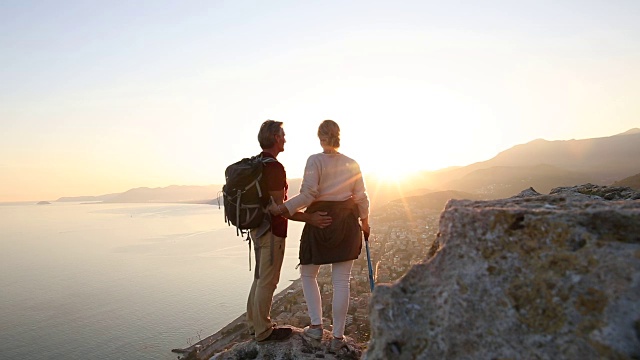 徒步旅行的夫妇探索岩石悬崖以上的海岸线，大海视频素材