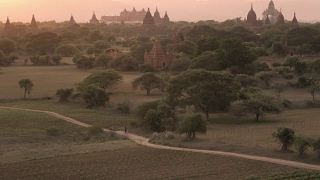 日落时分，缅甸蒲甘的当地骑自行车者和寺庙视频素材