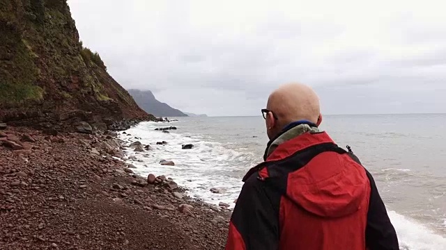 一个人在岩石海滩上行走视频下载