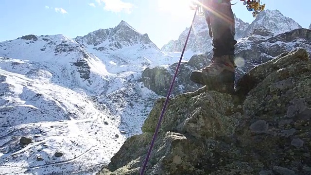 登山者从山顶向同伴伸出援助之手视频素材