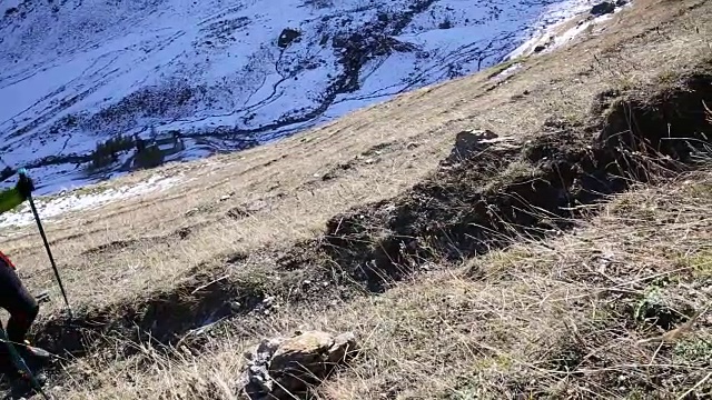 女性徒步者攀登山坡上的小径，后面是雪峰视频素材