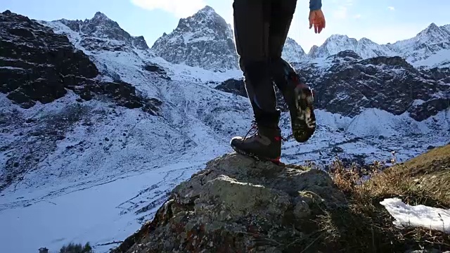 人类到达俯瞰山谷的岩石脊顶视频素材