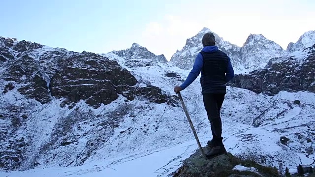 人类到达俯瞰山谷的岩石脊顶视频素材