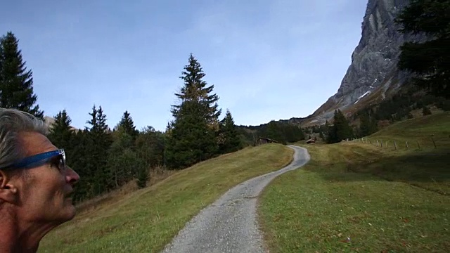 男性徒步旅行者沿着山间草地的小路行走视频素材