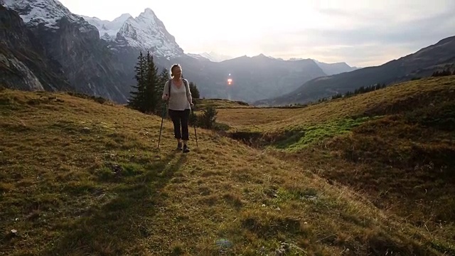 女徒步旅行者穿过山地草地视频素材