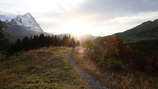 山地自行车手攀登穿过山地草地的小路视频素材