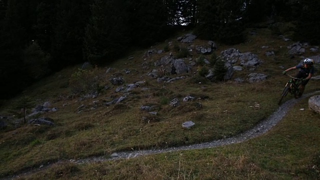 骑山地车的人沿着小路穿过山地草地视频素材