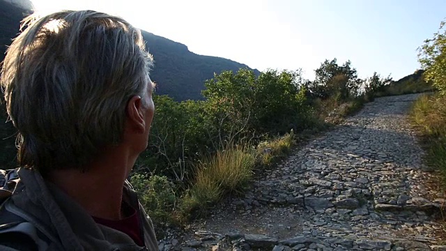 男徒步者走上鹅卵石小路，远山，日出视频素材