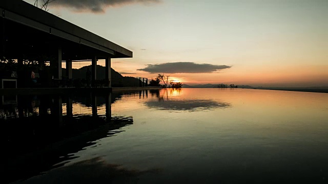 金色的夕阳映在荡漾的游泳池水面上。间隔拍摄视频素材