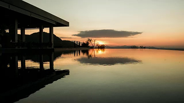 金色的夕阳映在荡漾的游泳池水面上。间隔拍摄视频素材