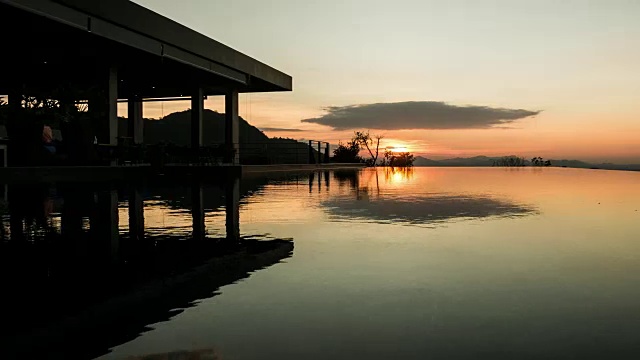 金色的夕阳映在荡漾的游泳池水面上。间隔拍摄视频素材