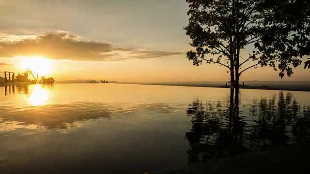 金色的夕阳映在荡漾的游泳池水面上。间隔拍摄视频素材