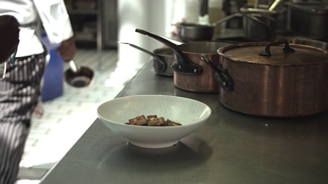 厨师在厨房里完成菜肴，在餐厅里视频素材