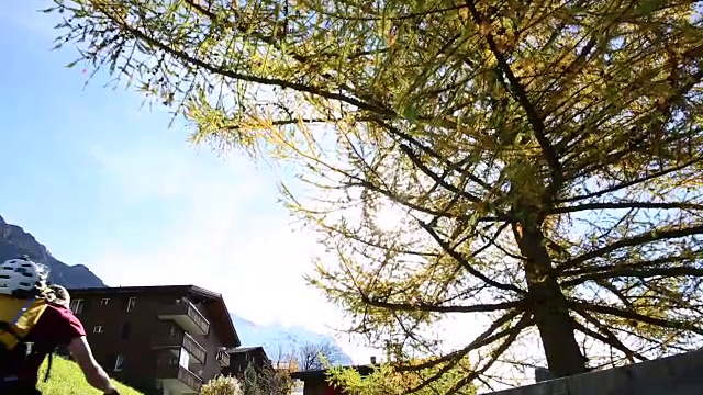 骑山地车的人沿着小路上山穿过山村视频素材