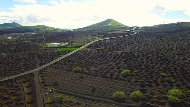 无人机在兰萨罗特火山岛上空拍摄的航拍镜头，令人惊叹的火山景观和黑色土地上葡萄园的漂亮图案洞。4 k UHD。视频素材