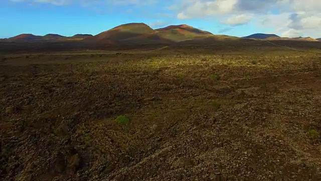 无人机在兰萨罗特岛上空拍摄的航拍镜头，以提曼法亚国家公园为背景，拍摄了令人惊叹的火山景观和黑土地上令人惊叹的长直道。4 k UHD。视频素材